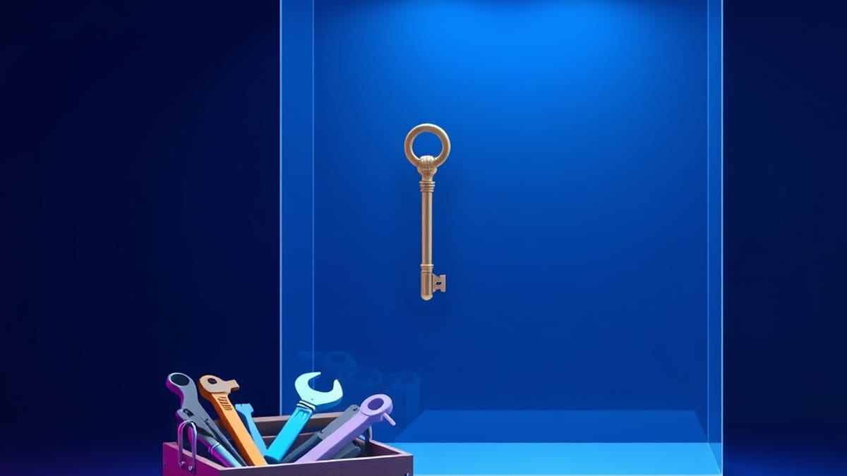A small toolbox of simple hand tools next to a large empty glass case displaying one ornate key.