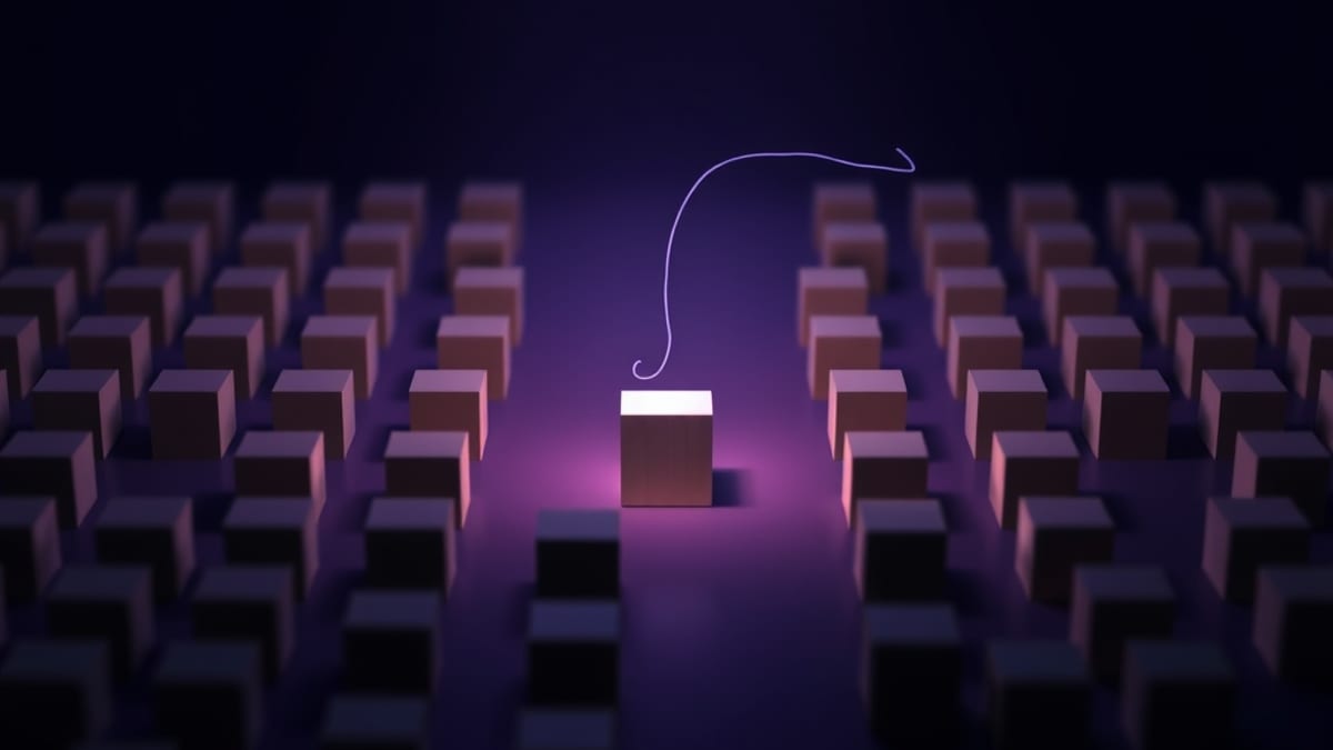 A narrow beam of light illuminates one small wooden block on a table while blurred identical blocks sit in shadow around it.