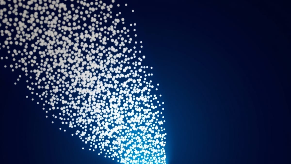 Many scattered pale dots narrowing through a funnel into one sharp dark rectangle on a clean surface.
