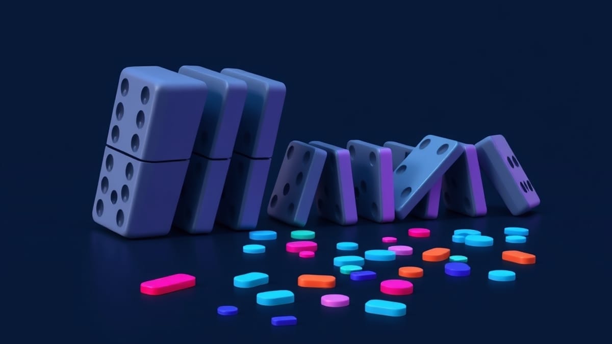A neat row of identical grey dominoes falls into a scattered, irregular line of mismatched colored tiles leaning at odd angle