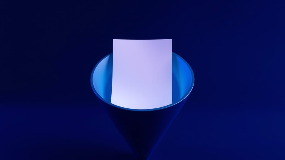A sheet of paper passing through a fixed funnel that neatly straightens its edges as it comes out the other side.