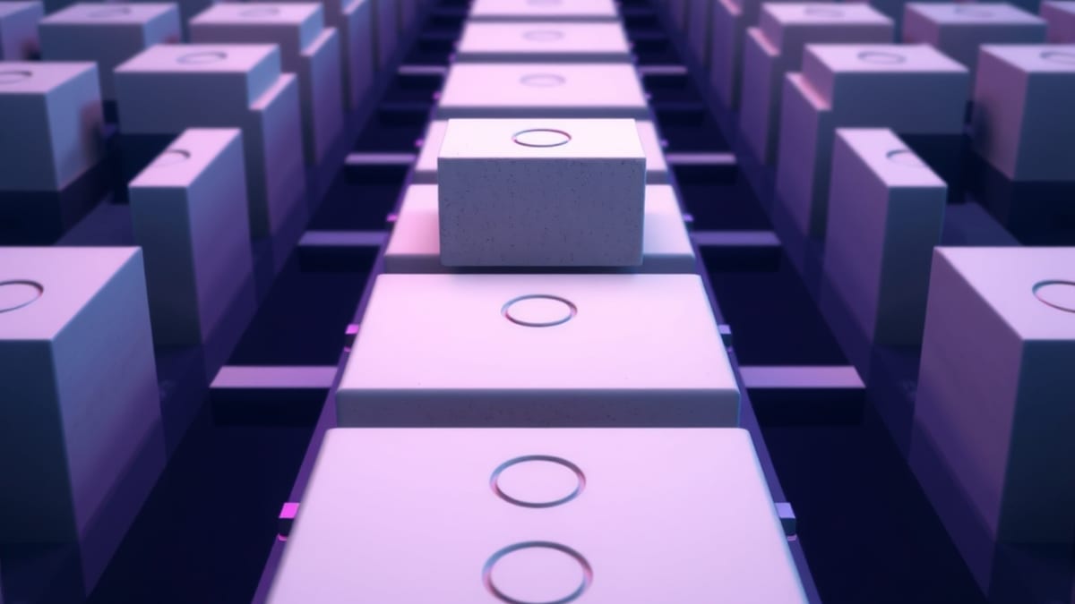 Rows of identical grey clay blocks on a conveyor belt, one block pulled aside onto a lit inspection table.
