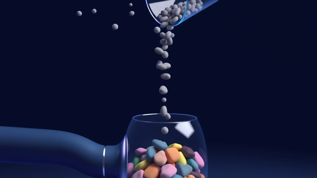 A funnel releasing identical grey pebbles while a pipe feeds a dense cluster of distinct colorful stones into a glass jar.